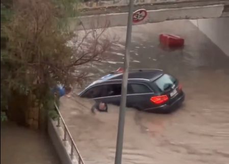 Un hombre sale de su coche en Altea este domingo, después de que el agua lo arrastre hacia el interior de un paso subterráneo.