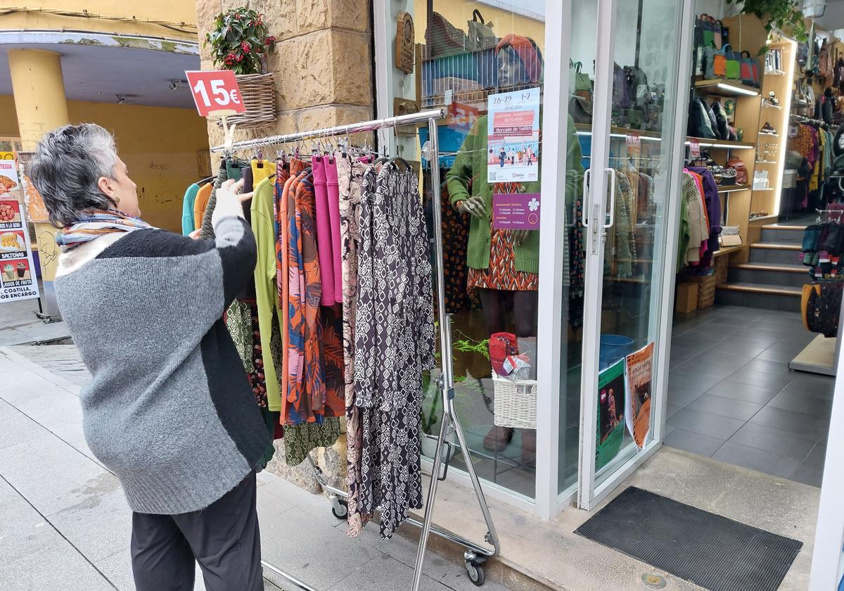 Un comerciante de Getxo ordena su mercancia en un mercado de gangas.