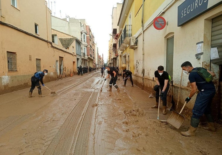 Policías locales de Vitoria ayudan en la limpieza de una calle de la localidad valenciana de Massanassa.