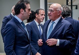 El ministro de Economía, Carlos Cuerpo, charla con el presidente del Sabadell, Josep Oliu.