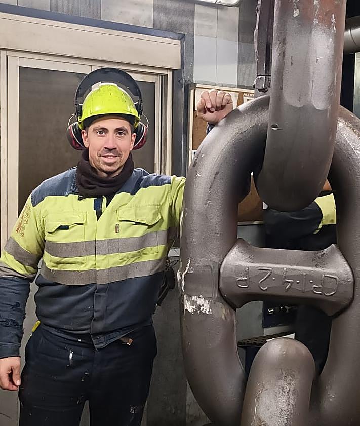 Imagen secundaria 2 - Jorge se prepara para hacer sentadillas. En la siguiente foto, con la medalla conseguida en el campeonato de España. En la última imagen, junto a una de las enormes cadenas con las que trabaja.