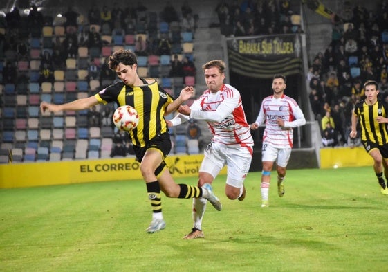 Un jugador de la Ponferradina agarra a Aimar Vicandi, impidiendo su avanzada.