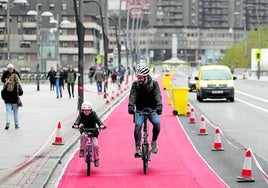 Un aita y su hijo disfrutan ayer del nuevo carril bici que atraviesa el puente de Deusto.