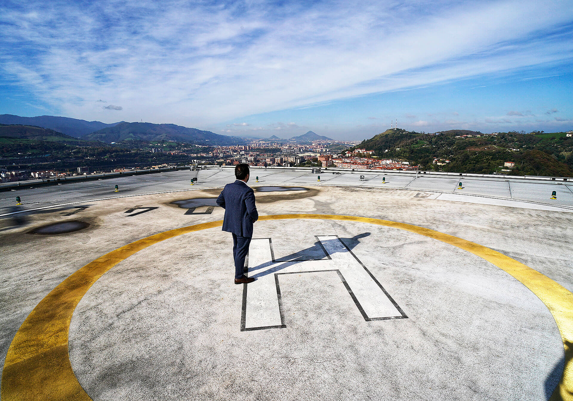 Un trabajador de la torre contempla el panorama desde el helipuerto de la azotea, con el Serantes al fondo.