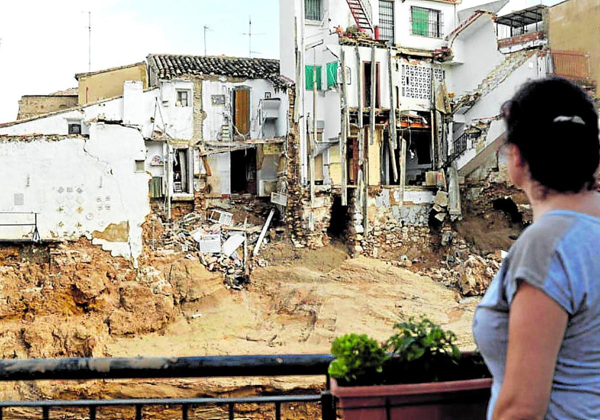 Una mujer observa varias casas dañadas en la localidad valenciana de Chiva.