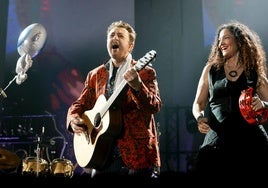 Manolo García toca la guitarra en presencia de una de las músicas de la banda que le acompañó.