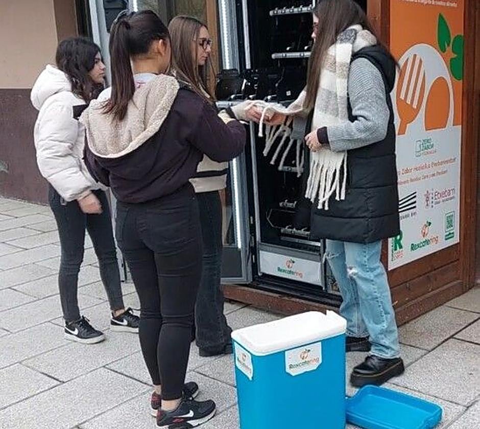 Alumnas del instituto de Etxebarri introducen platos en la maquina expendedora de recuperación de alimentos