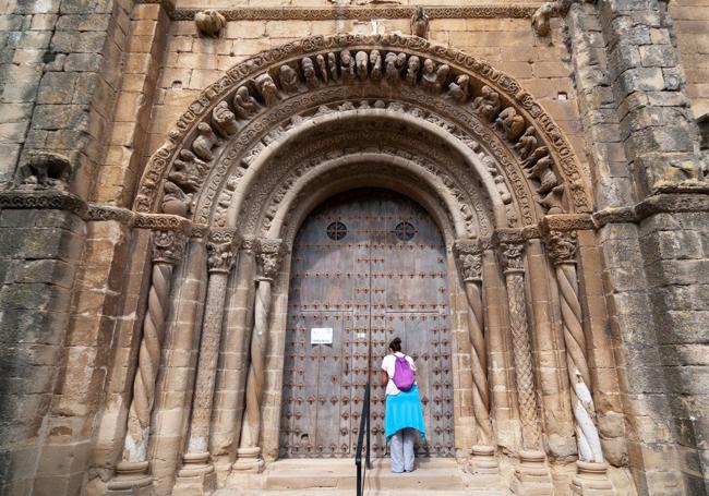 Una turista en la portada románica de la iglesia de Uncastillo.