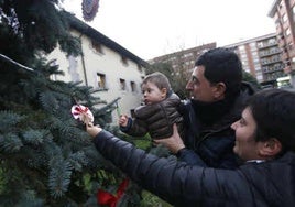 Vecinos de Ugao adornan un árbol de Navidad.