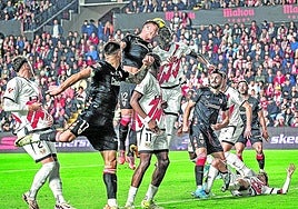 Ante la mirada de varios compañeros, Guruzeta disputa de cabeza un balón por alto con Ziss en un momento del partido del domingo en Vallecas.