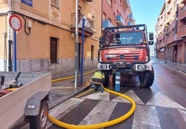 Personal municipal trabaja para reducir el agua en un alcantarilla después del desbordamiento de la ría en Erandio.