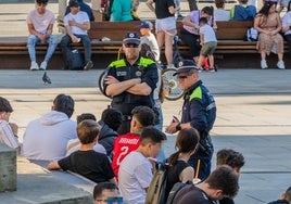 Agentes locales conversan con varios adolescentes en la plaza de la Virgen Blanca.