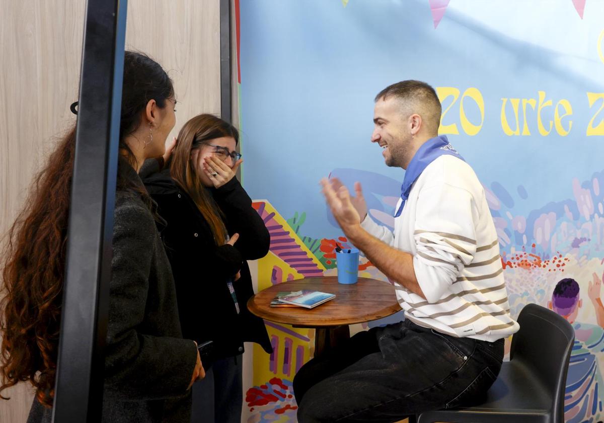 Imagen principal - El cantante y guitarra de ETS, Iñigo Etxezarreta, charla con unas fans. Y Josune Arakistain y Aiora Renteria firman sus trabajos a unas seguidoras. 