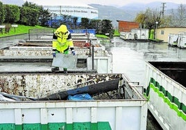 Un operario arroja desechos a un contenedor del garbigune de Santurtzi.