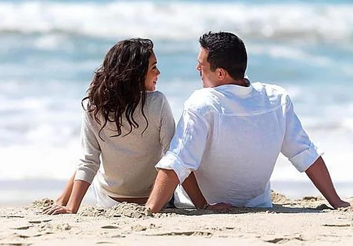 Una pareja de enamorados se declara su amor sobre la arena de la playa.