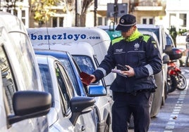 Un policía municipal pone una multa.