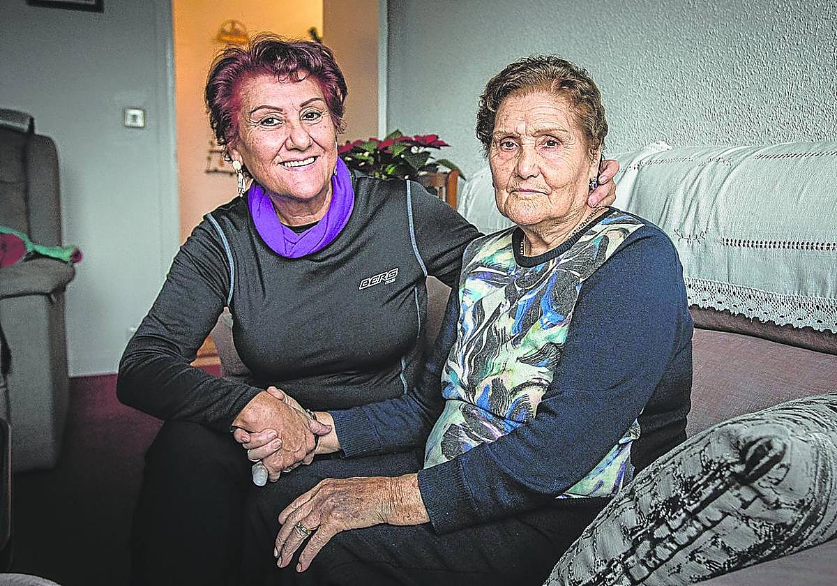 Ana Fínez sujeta de la mano a su madre, Baltasara, ya en su casa después de esperar doce horas a una ambulancia tras recibir el alta.