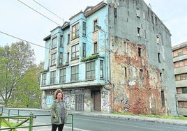 Sofia Basterretxea frente al edificio donde reside en Sestao, junto a sus dos hijos, con parte de la fachada dañada por un derribo anterior.