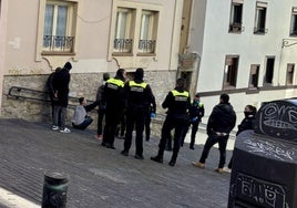 Agentes locales interrogan a uno de los okupas de la lonja de Correría el pasado domingo.