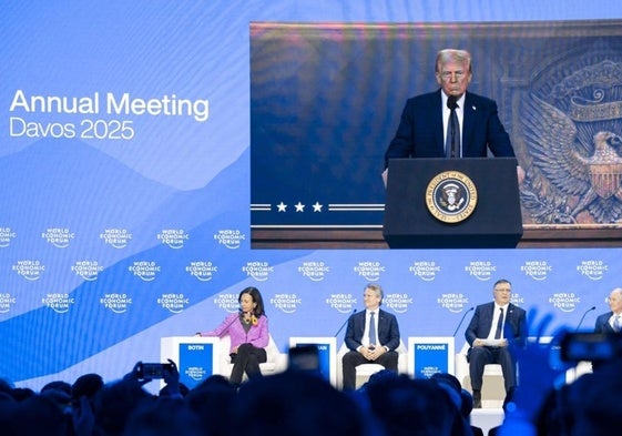 Donald Trump aparece en una pantalla mientras se dirige a través de una conexión remota a una sesión plenaria en Davos.