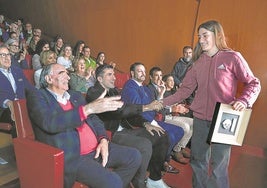 José Ángel Iribar y Dani Vivián felicitan con un choque de manos a la skater bermeotarra Naia Laso al bajar del escenario del Guggenheim con su premio.