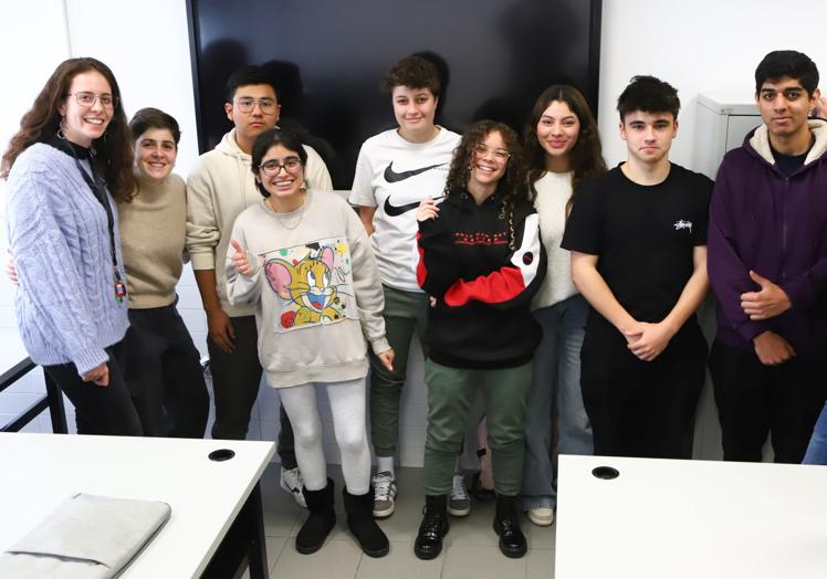 Siete de los alumnos participantes con una de las profesoras implicadas y una de las estudiantes realizando cálculos en un programa informático.