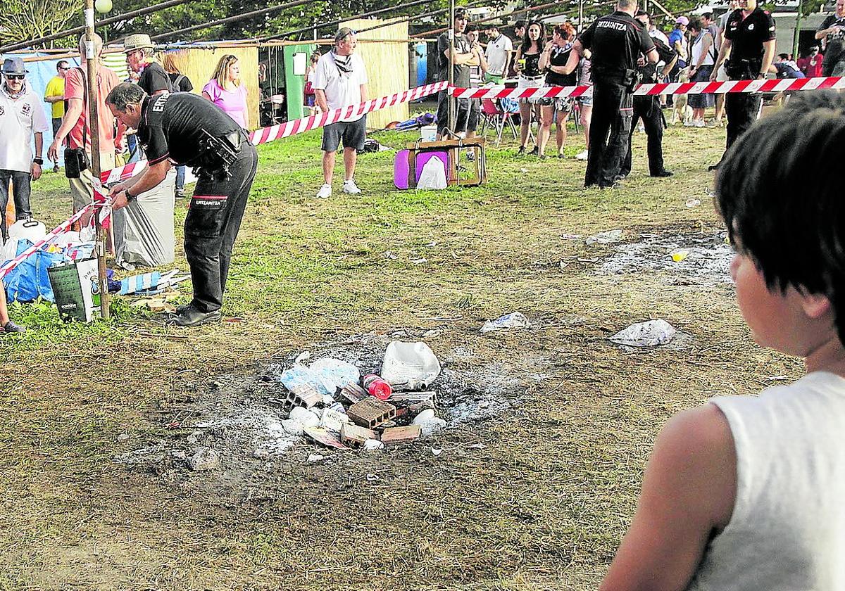 Un agente de la Ertzaintza acordona la zona del recinto festivo de Aixerrota donde se produjo el fatal incendio de 2017.