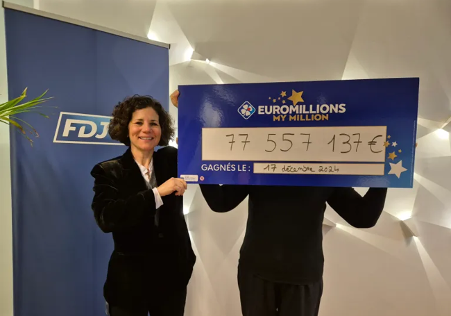 La ganadora sostiene el cheque.