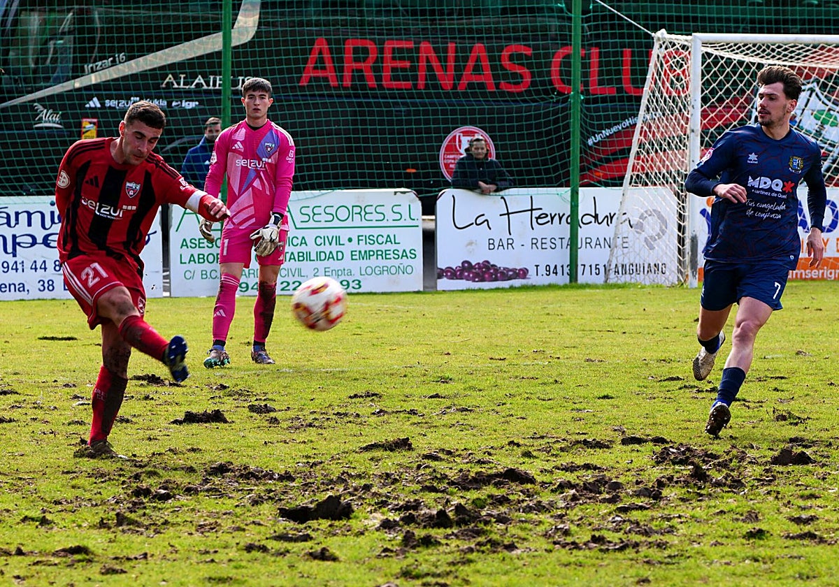 Jon Sillero realiza un pase largo sobre el maltrecho césped del Anguiano.