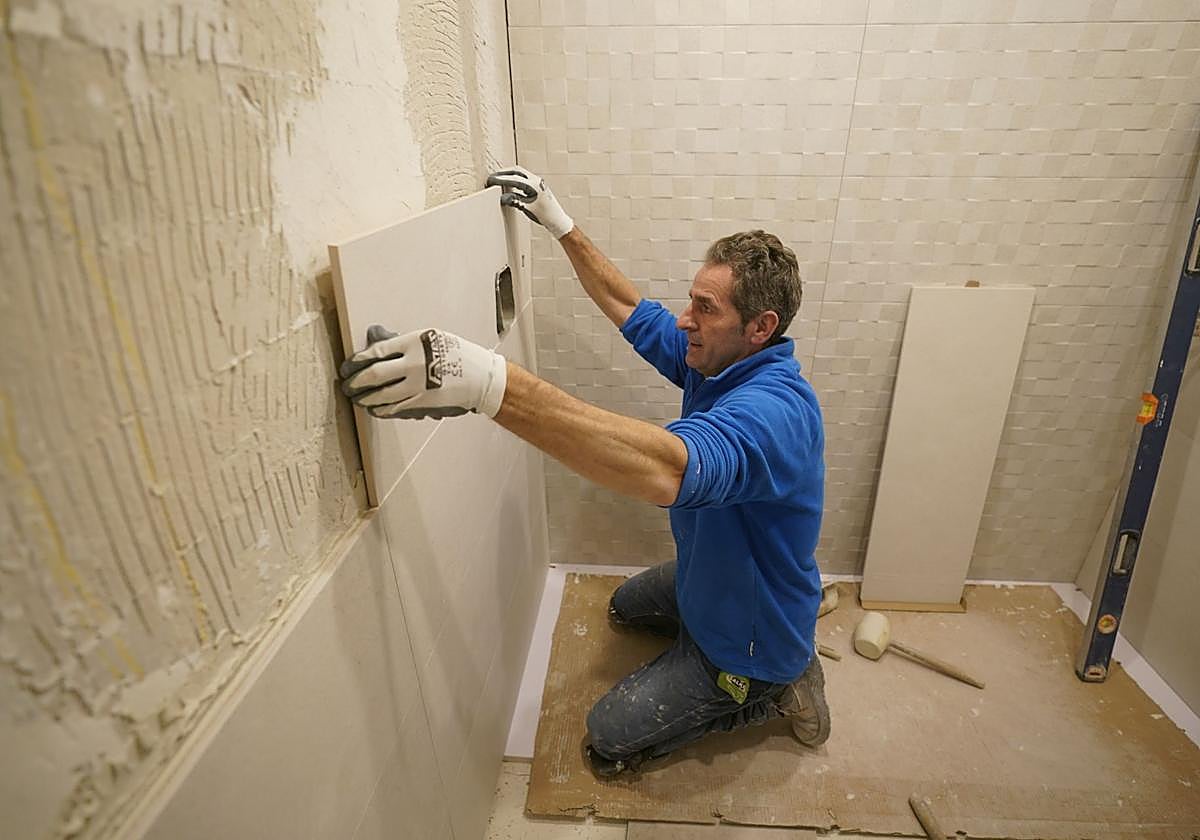 Un albañil acomete el cambio de una bañera por una ducha.