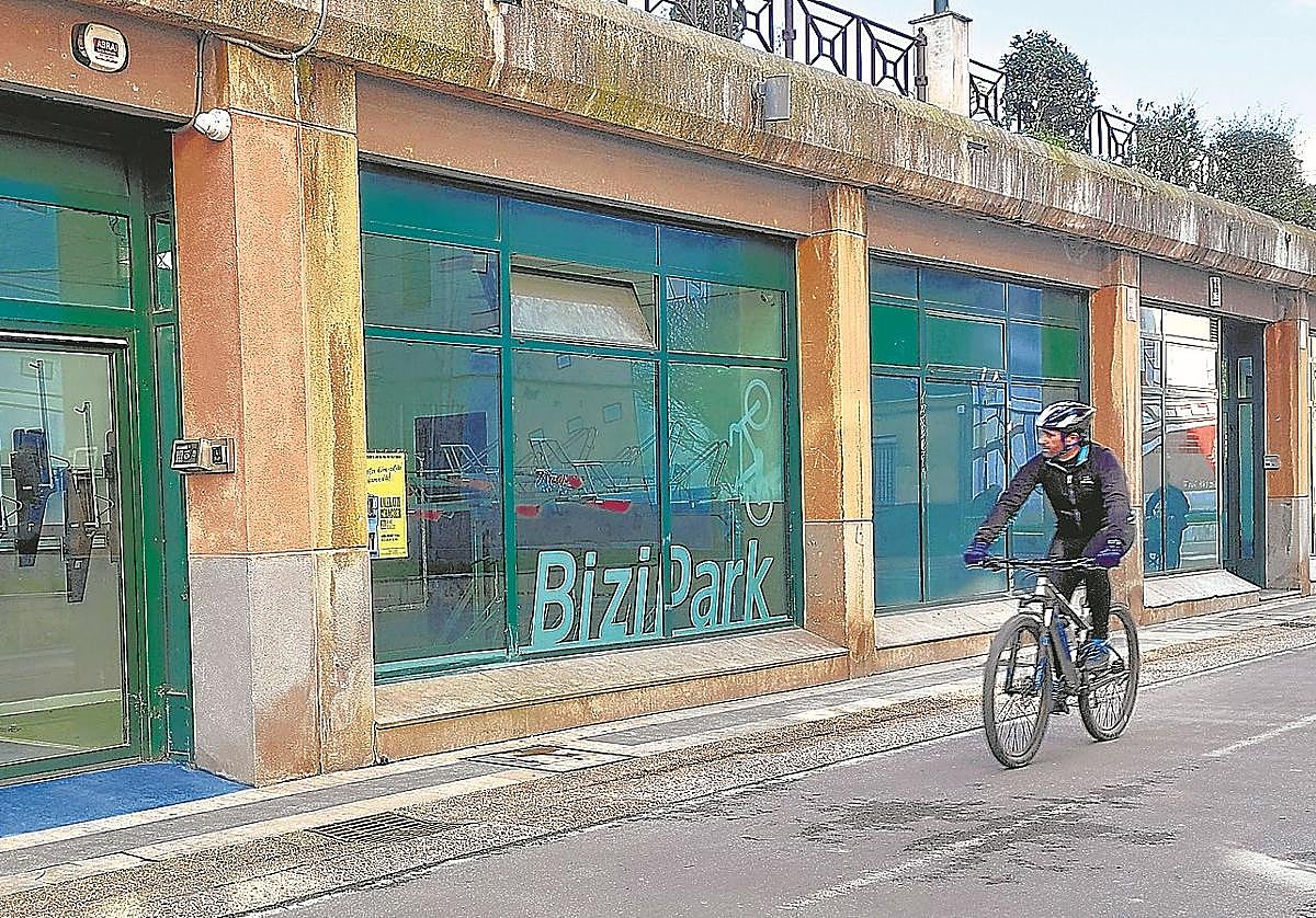 Un ciclista observa el interior del local municipal adaptado como aparcamiento de bicicletas, mientras circula por el bidegorri.