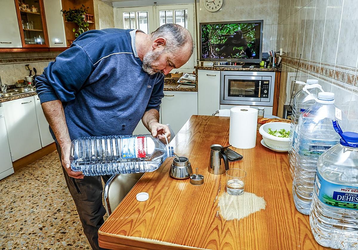 Un vecino afectado prepara café con agua embotellada.