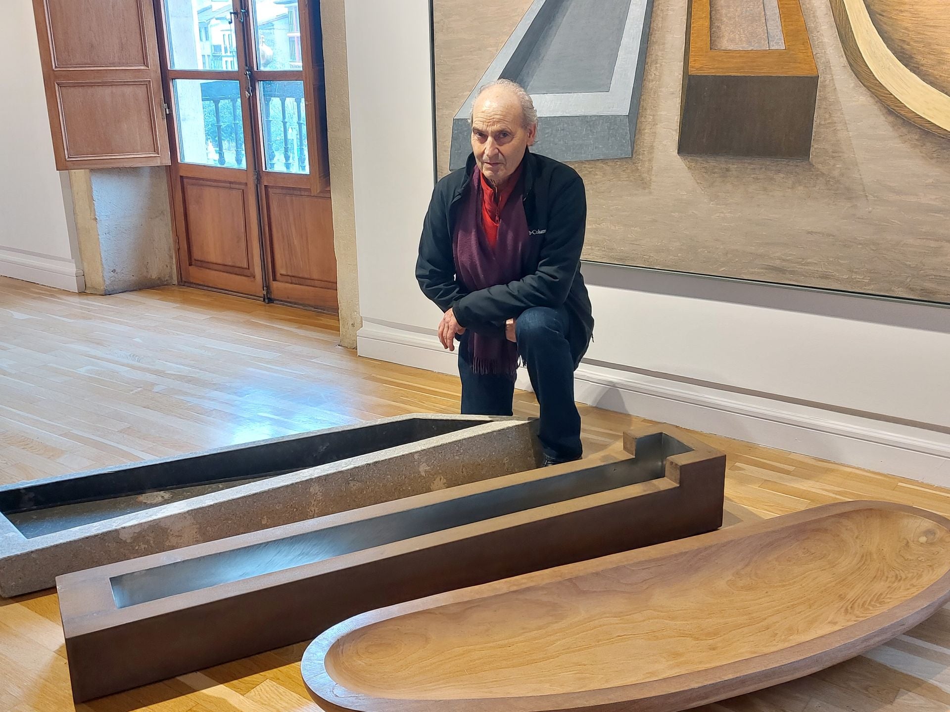 El artista, Mikel Lertxundi, junto a una de sus obras expuestas en el espacio cultural.