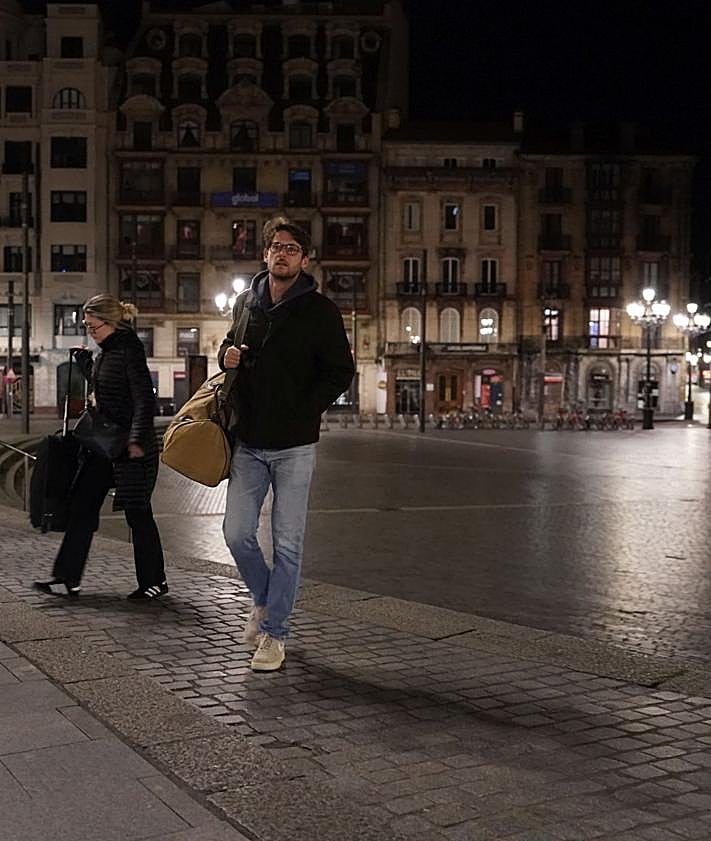 Imagen secundaria 2 - Un taxista recoge a una clienta. Jesús Mari trabaja en una farola de la calle Aurrekoetxea. Los menorquines Roser y Óscar cruzan la plaza del Arriaga. 
