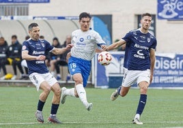 Diego Morcillo lucha por un balón frente a dos defensores del Utebo.