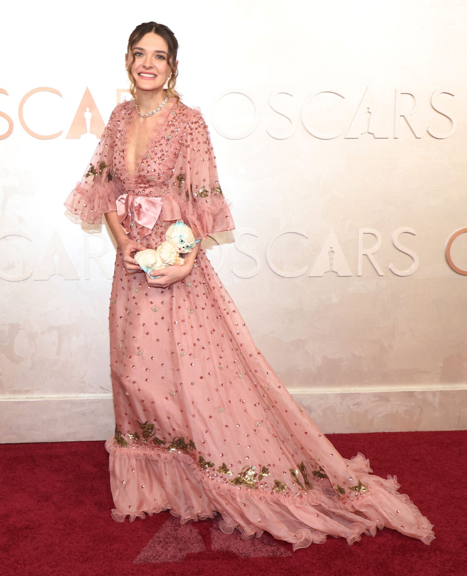 Charlotte Lawrence se ha decantado por el romanticismo de este vestido rosa de tul con volantes y lentejuelas de Valentino. ¿Lo mejor? Su bolso-gato, que no ha querido perderse la gala. También es de la marca italiana.