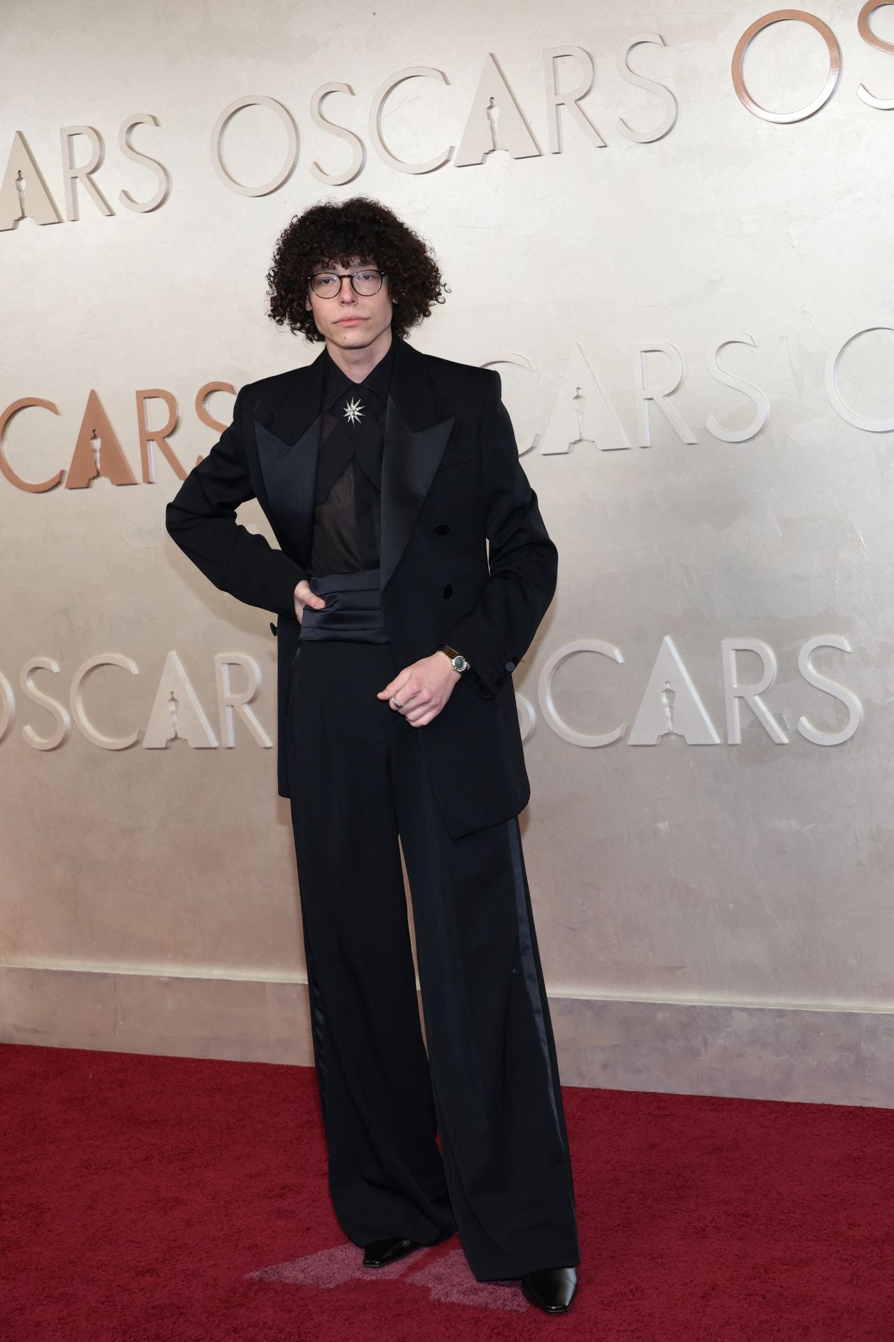 El actor Reece Feldman, fiel a sí mismo con este conjunto negro compuesto por camisa transparente y pantalones acampanados.