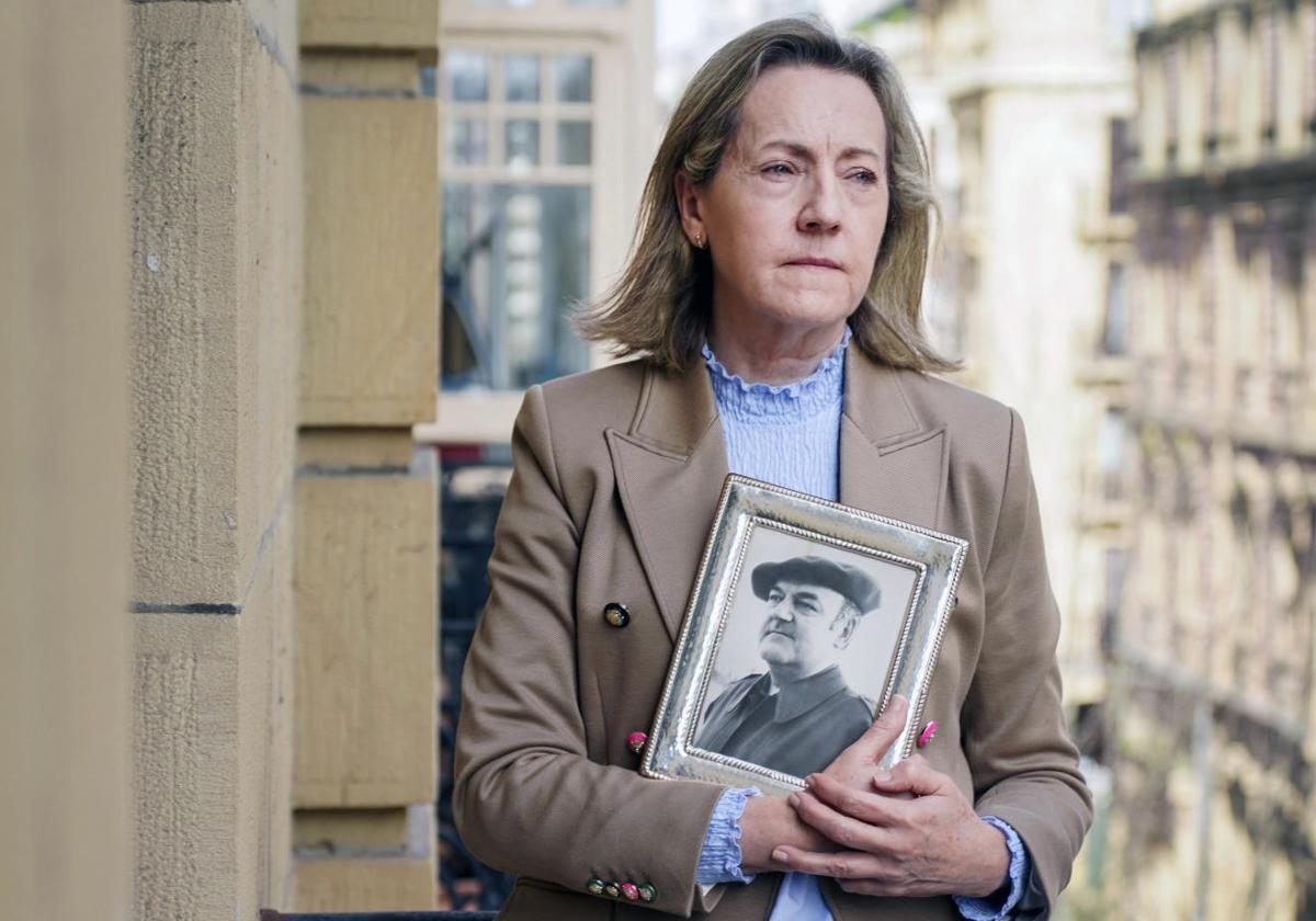 Teresa Díaz Bada posa en la terraza de su consulta de San Sebastián con un retrato de su padre.