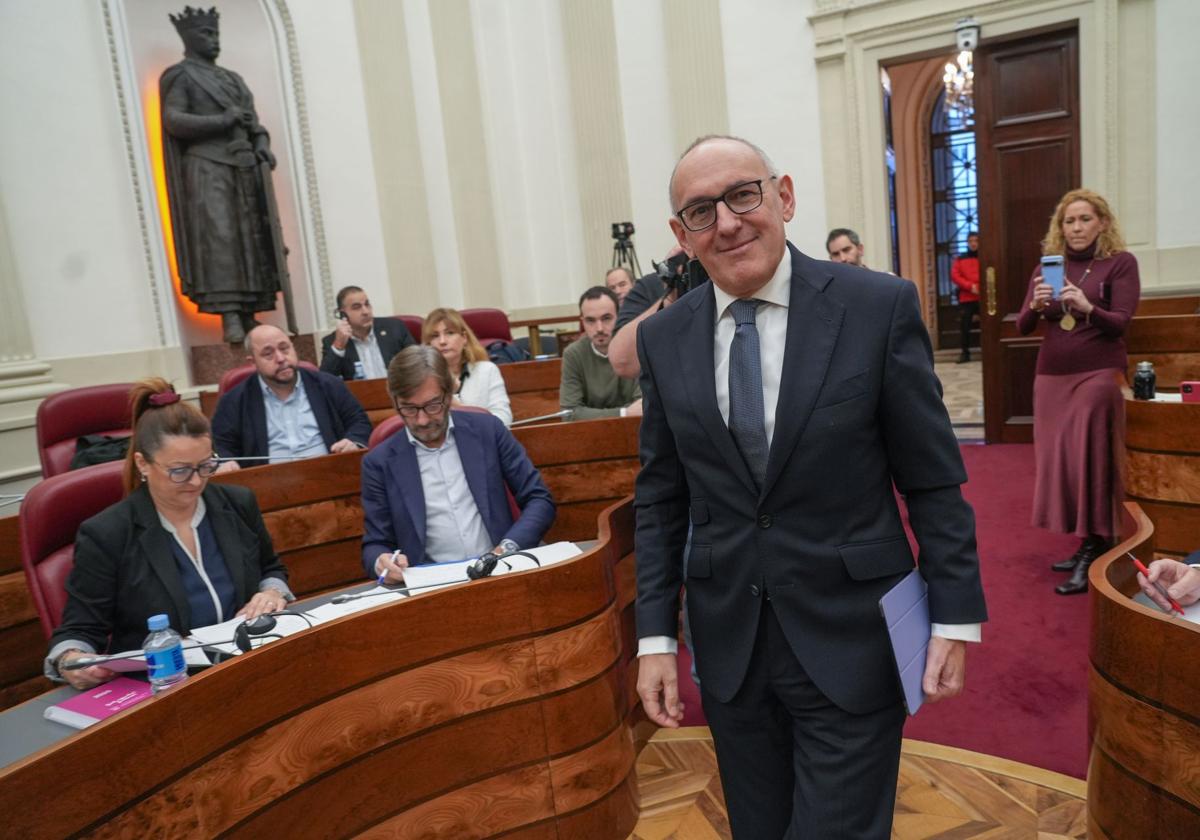 Ramiro González accede al salón de plenos con el juntero de Vox al fondo.