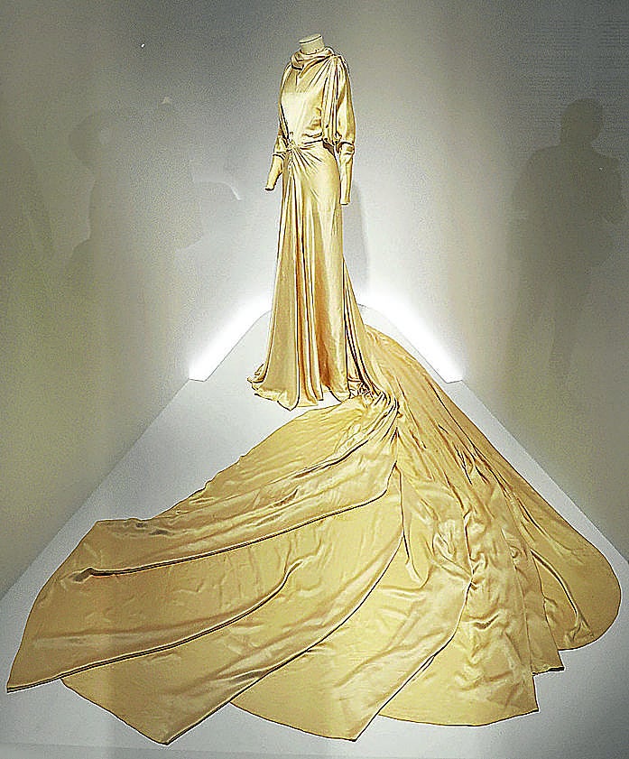 Imagen secundaria 2 - Varios modelos de cóctel en tonos rojos. Chaqueta de noche en 'voluptuese', tejido estampado y con bandas de lamé, de Coudurier, Fructus y Descher. Vestido de novia en crepe satén de color marfil, regalo personal de Balenciaga a la hija del neurólogo donostiarra Benigno Oreja (1935). 