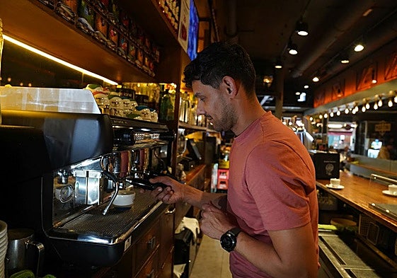 Un hostelero prepara un café con leche en un local de Ledesma.