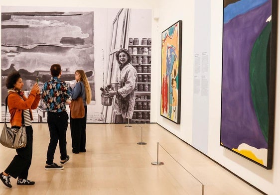Una zona de la exposición donde puede verse a la artista en una gran foto, junto a los cuadros 'Santorini' (1966), y 'Pensamientos mediterráneos' (1960).