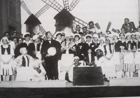 Integrantes del Orfeón sobre el escenario en una representación de 1927, ante el decorado de la obra 'Molinos de Viento'.