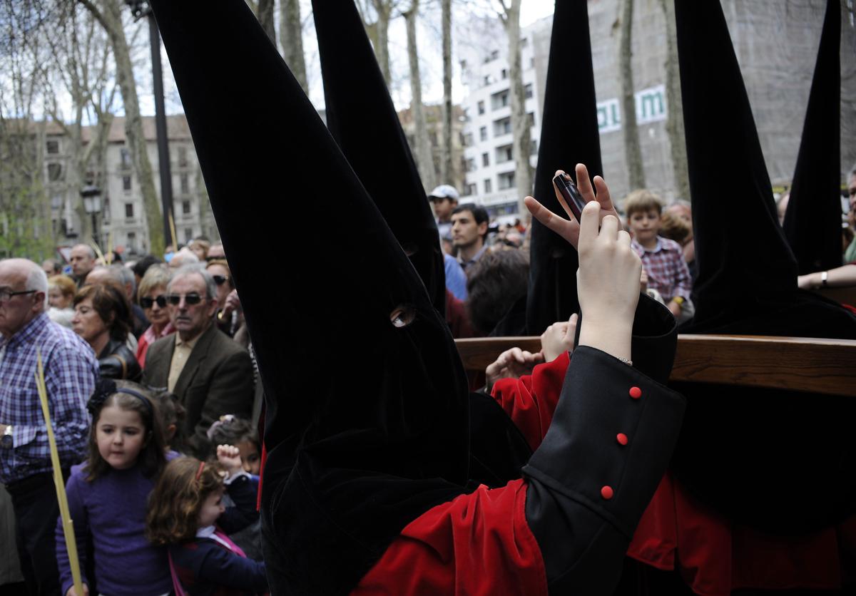 Imagen principal - Cofrades de La Pasión en otra de sus procesiones, la del Borriquito, y dos imágenes de su txosna.