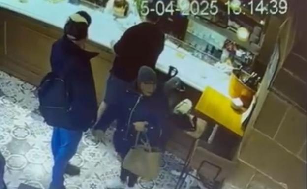 La pareja de ladrones se prepara para robar la riñonera al cliente apoyado en la barra.