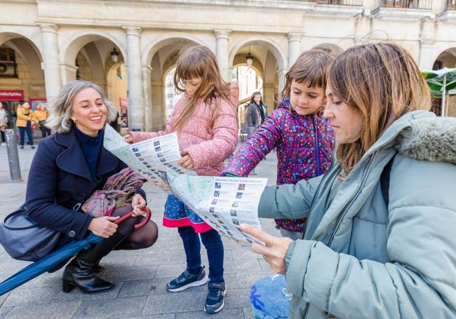 Marta y Carmen señalan a Gala y Alma donde está la plaza de España en el mapa.