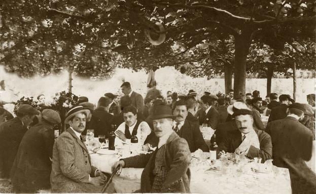 Comida de inauguración del txakoli de Pantaleón Rementería (que luego gestionaría su hija Juana) en Landako. Canotiers, hongos, gorras y boinas cubren a los asistentes que beben txakoli tinto.