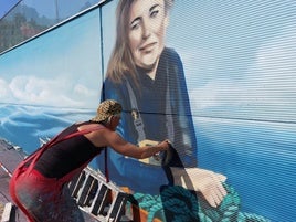 La artista callejera Lian Monserrate muestra dos de sus aerosoles.