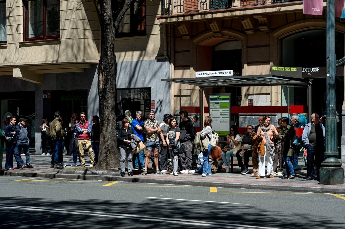 Los transeúntes esperan la llegada del autobús ante la incertidumbre.