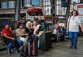 Viajeros esperan al tren en la estación de Abando.